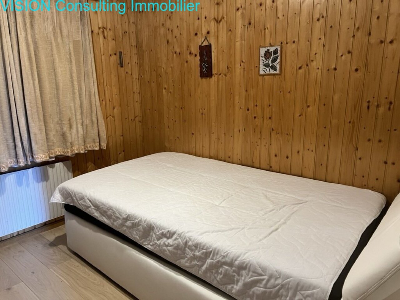 Schlafzimmer mit wärmespeichernder Holzverkleidung und Heizkörper Schlafzimmer mit wärmespeichernder Holzverkleidung und Heizkörper